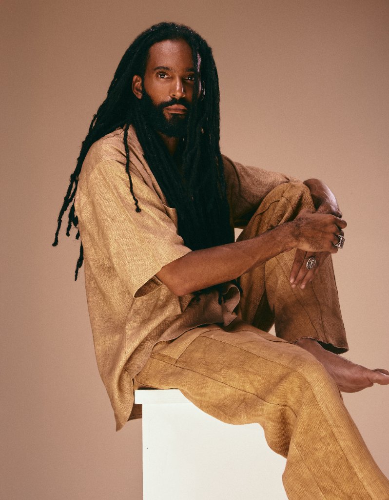 Homme assis aux longues locks, tenue de lin